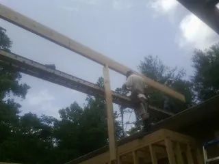 Carpenter setting a ridge beam over a new addition frame — Ice Dam Removal by Roofing Brothers in Glen Ridge