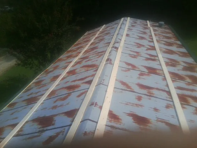 Rusted metal roof panels with new wood purlins before replacement — Storm Damage Roof Repair in Glen Ridge by Roofing Brothers