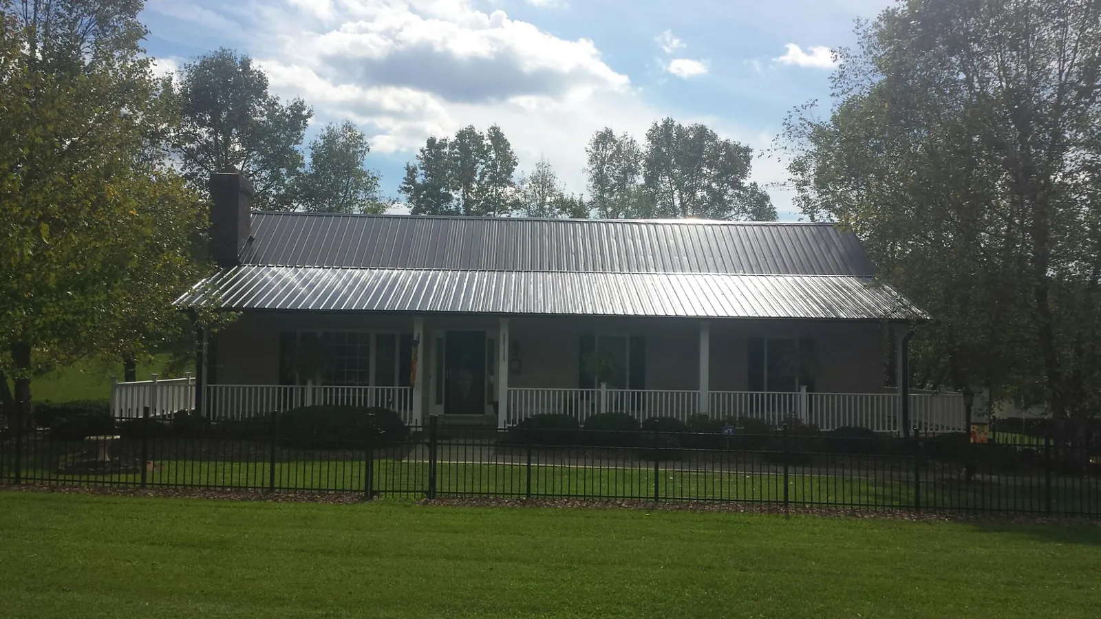 Gray metal roof on a brick ranch with a full width front porch — Gutter Guard Installation work by our crew in Glen Ridge