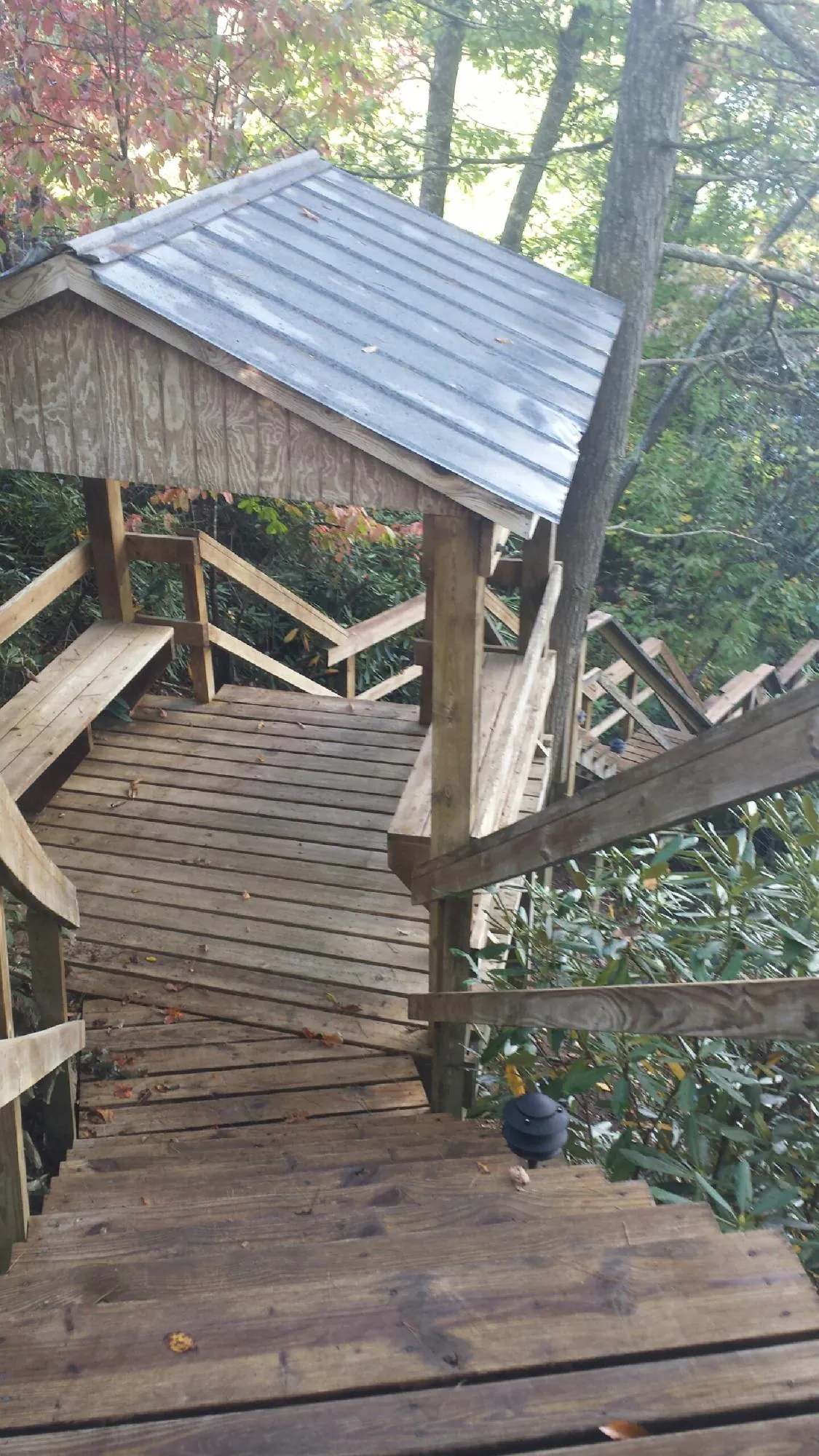 Metal roofed shelter over wooden steps on a wooded walkway — Skylight Repair & Installation work by our crew in Glen Ridge